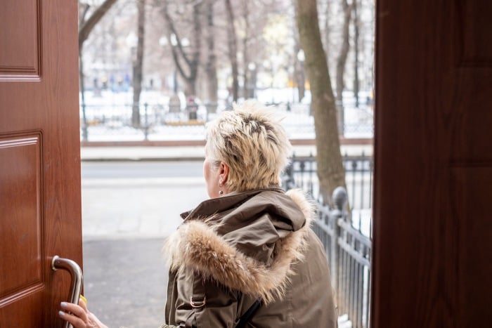 Frau verlässt Haus im Winter