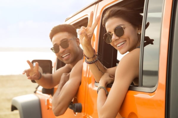 Junge Leute mit einem Auto am Strand