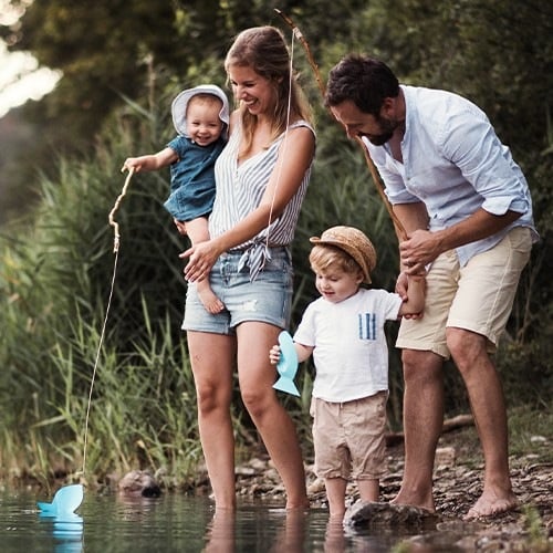 Vierköpfige Familie angelt bei einem Teich