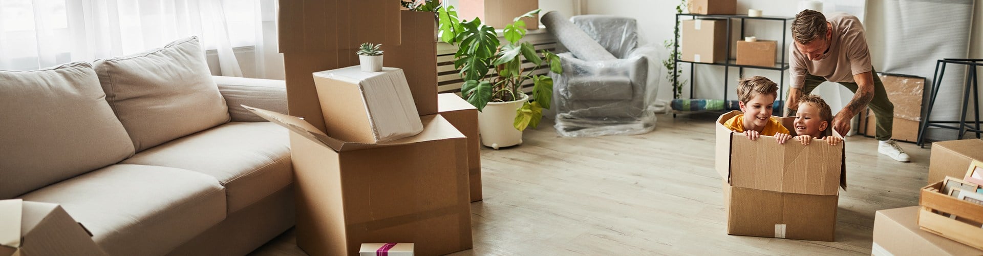 Vater mit zwei Buben, die in der Kiste geschoben werden