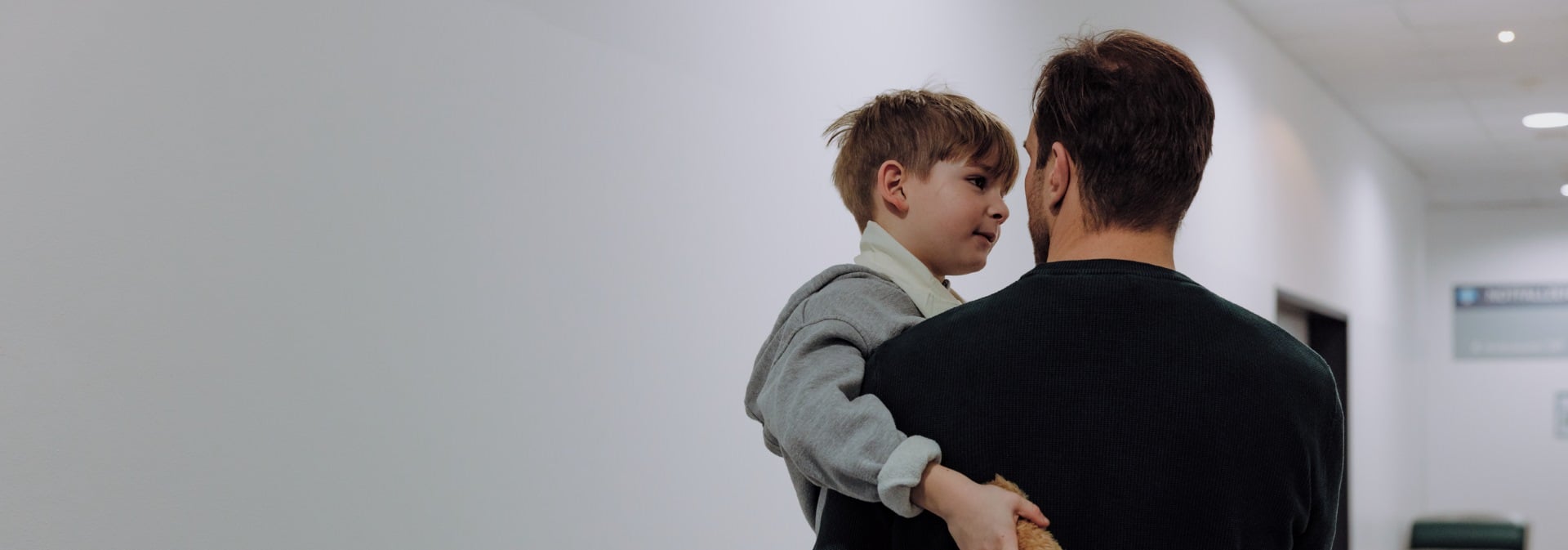 Vater traegt sein Kind im Spital