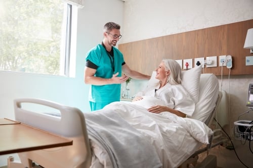 Arzt kümmert sich um Patientin im Krankenhauszimmer