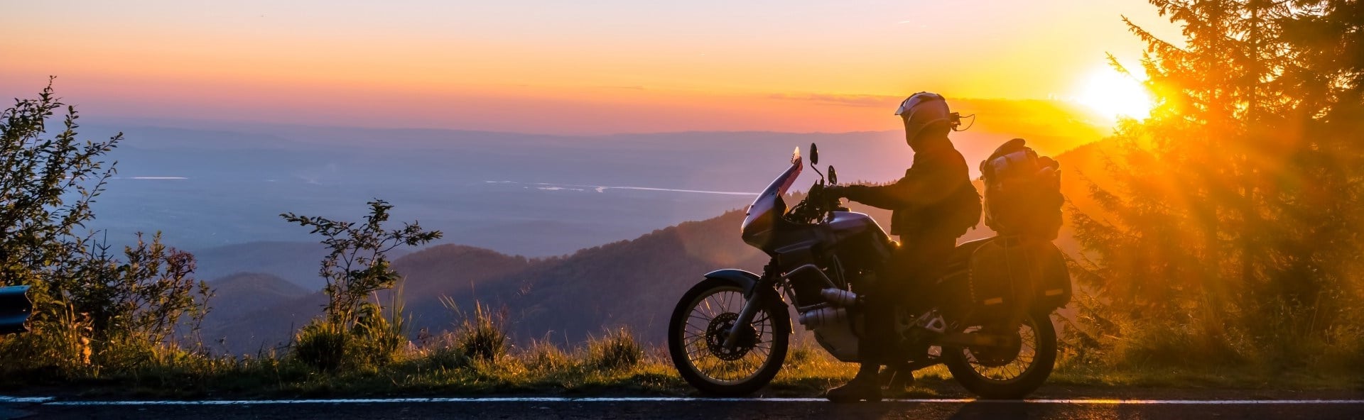 Person sitzt auf Motorrad mit einer Aussicht