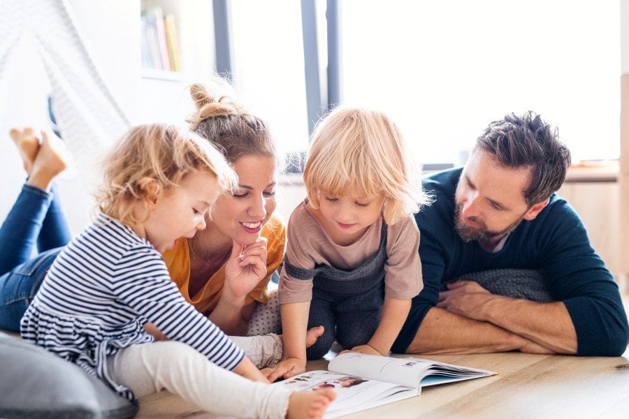 Familie liegt am Boden und liest
